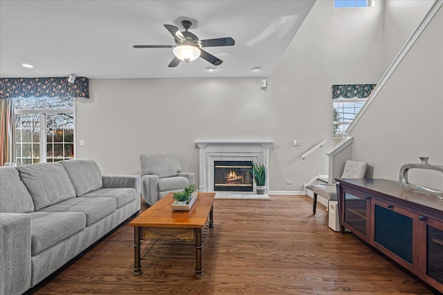 living room with dark wood-type flooring and ceiling fan