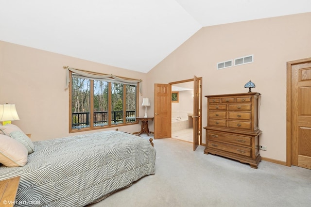 bedroom featuring light carpet, high vaulted ceiling, and ensuite bath