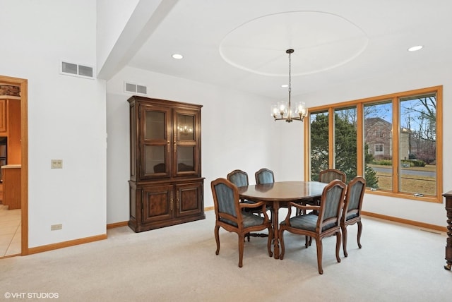 dining space featuring a raised ceiling, light carpet, and an inviting chandelier