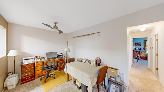 carpeted home office featuring ceiling fan