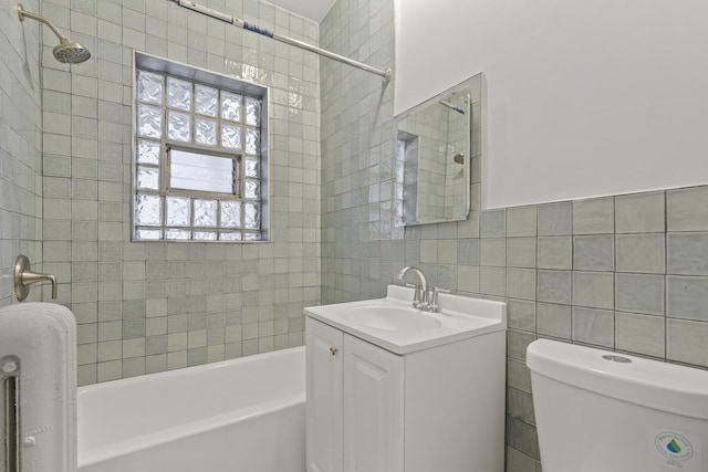 bathroom featuring vanity, tile walls, and toilet