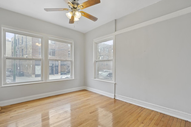 spare room featuring light hardwood / wood-style flooring, a wealth of natural light, and ceiling fan