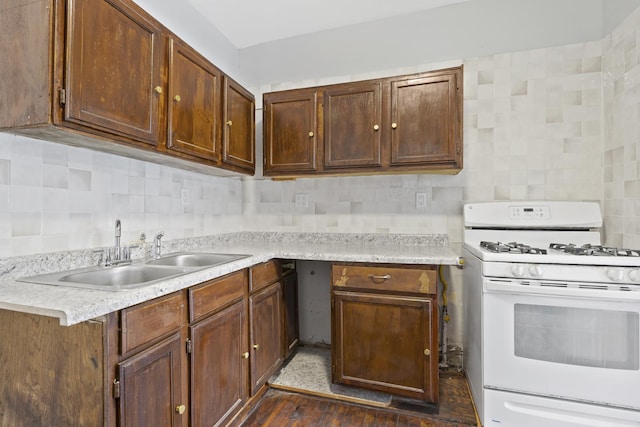 kitchen featuring sink, decorative backsplash, dark hardwood / wood-style floors, and white gas range oven