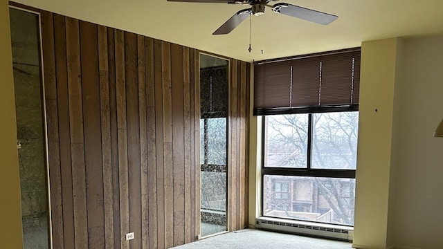 interior space featuring a baseboard heating unit and ceiling fan