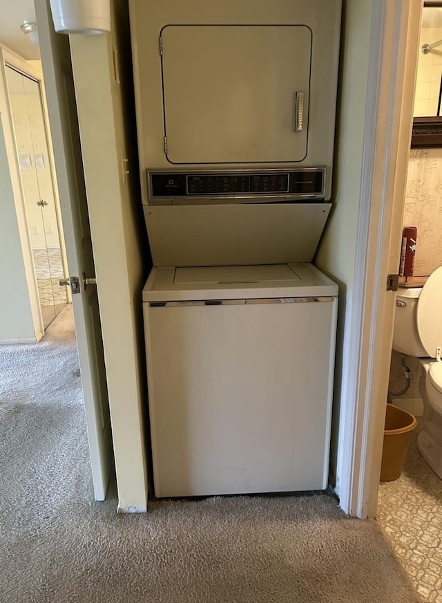 laundry room with light colored carpet and stacked washer and clothes dryer