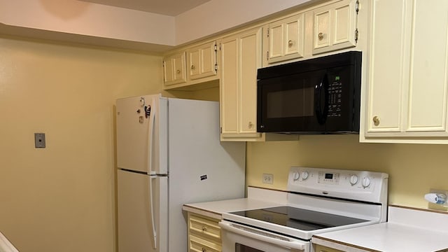 kitchen featuring cream cabinets and white appliances