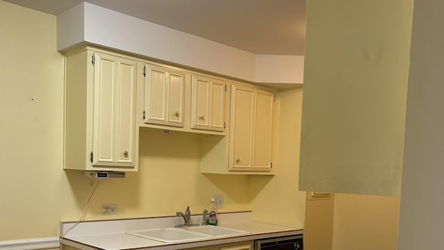 kitchen featuring cream cabinets, dishwashing machine, and sink