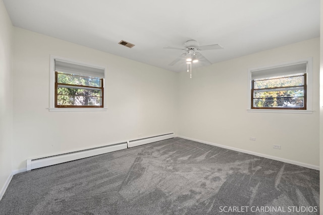 empty room with dark colored carpet, ceiling fan, and a baseboard heating unit