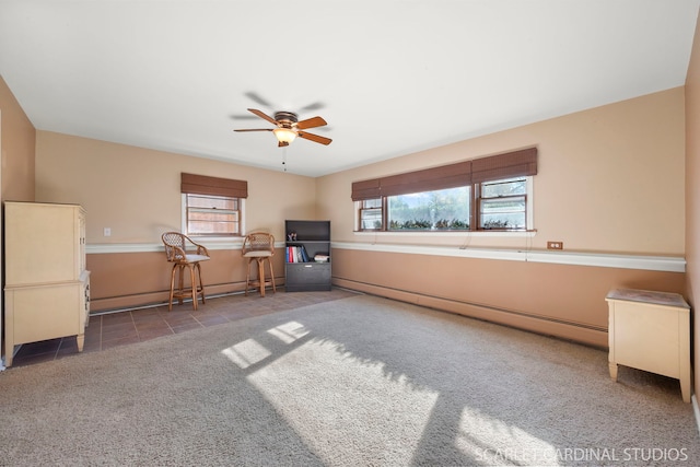 interior space with ceiling fan, plenty of natural light, tile patterned floors, and baseboard heating