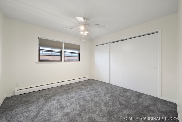 unfurnished bedroom with ceiling fan, dark carpet, a closet, and a baseboard heating unit