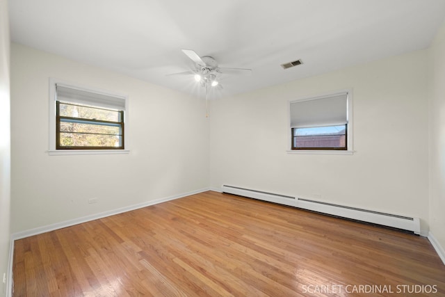 spare room with baseboard heating, ceiling fan, and light hardwood / wood-style flooring