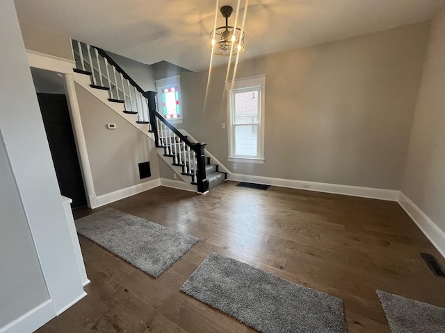 entryway featuring an inviting chandelier and dark hardwood / wood-style flooring