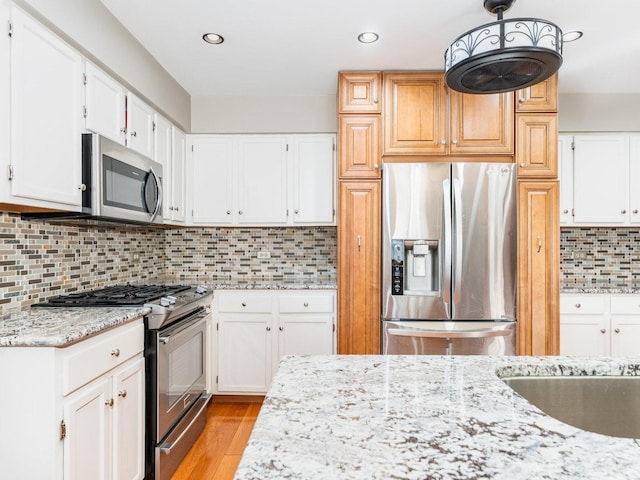 37W751 Orchard Ln, Elgin, IL 60124 - kitchen with stainless steel appliances, tasteful backsplash, light wood-style flooring, white cabinets, and light stone countertops