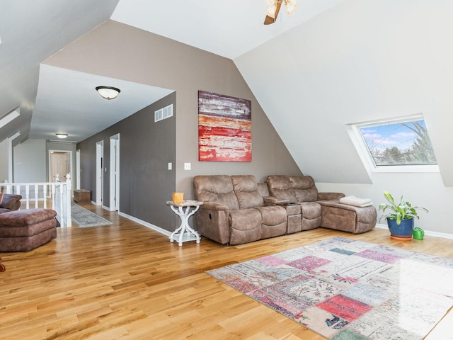 37W751 Orchard Ln, Elgin, IL 60124 - living area featuring vaulted ceiling with skylight, wood finished floors, visible vents, and baseboards