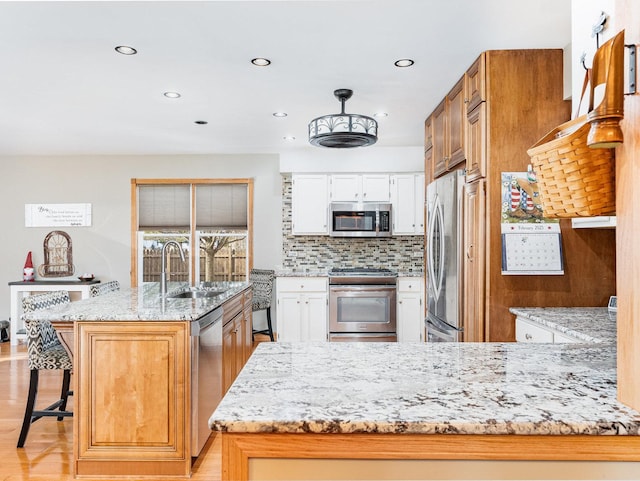 37W751 Orchard Ln, Elgin, IL 60124 - kitchen with stainless steel appliances, backsplash, a sink, light stone countertops, and a peninsula