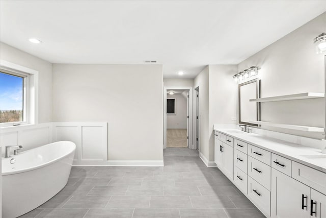 bathroom with a bathing tub and vanity