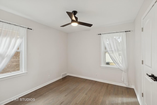 unfurnished room with ceiling fan and dark hardwood / wood-style flooring