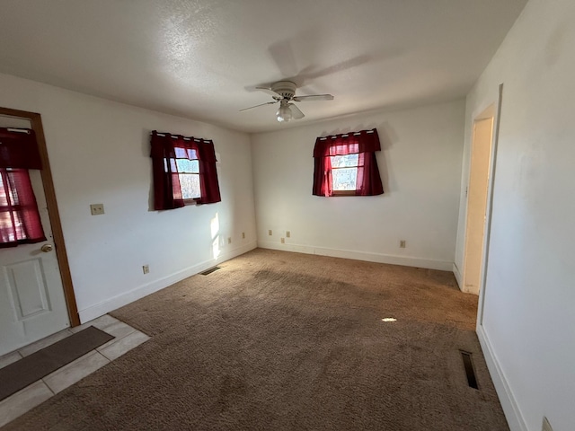 unfurnished room featuring plenty of natural light, light carpet, and ceiling fan