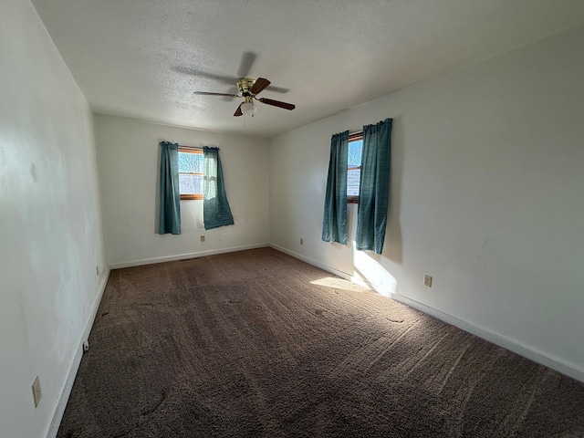 unfurnished room featuring ceiling fan, a textured ceiling, and dark colored carpet