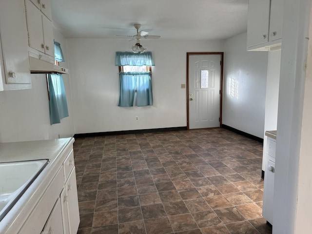 kitchen with sink, white cabinets, and ceiling fan