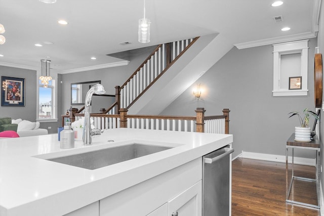 kitchen featuring dishwasher, sink, pendant lighting, and ornamental molding