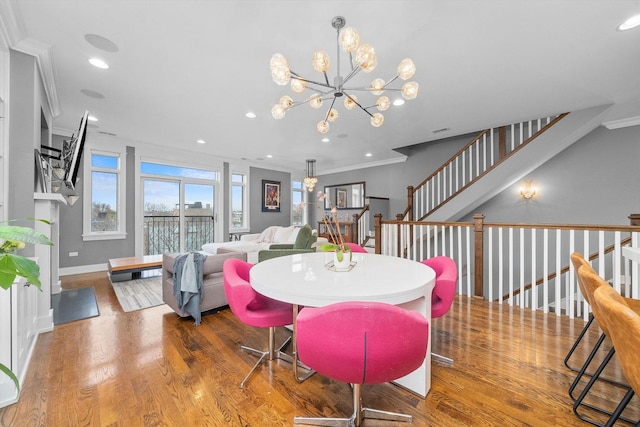 dining room with an inviting chandelier, hardwood / wood-style flooring, and ornamental molding