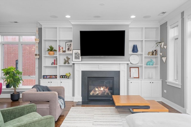 living room with ornamental molding, plenty of natural light, and wood-type flooring