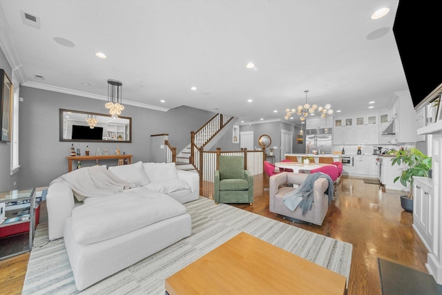 living room with crown molding, a notable chandelier, and light hardwood / wood-style floors