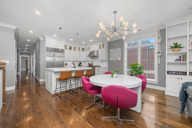 dining space with dark wood-type flooring, ornamental molding, and an inviting chandelier