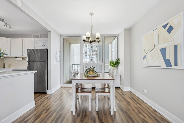 dining area with an inviting chandelier and dark hardwood / wood-style floors