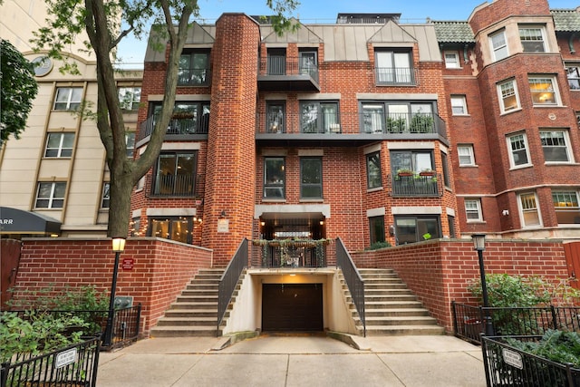 view of property featuring stairs, concrete driveway, and an attached garage