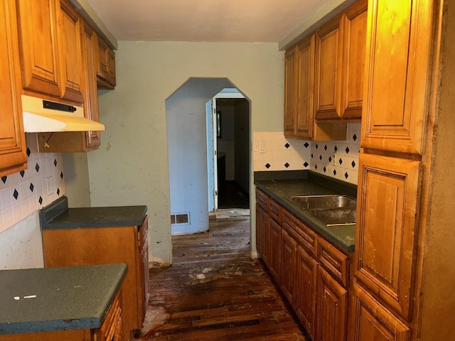 kitchen with dark wood-type flooring, sink, and decorative backsplash