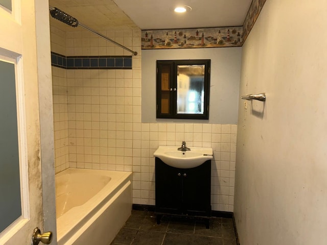 bathroom featuring tile patterned flooring, vanity, tile walls, and tiled shower / bath