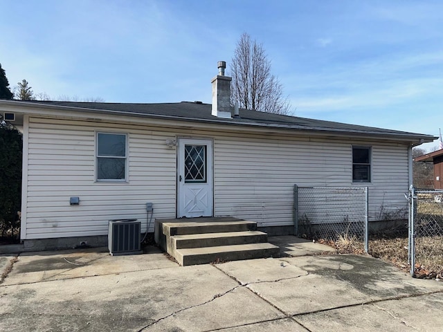 rear view of property featuring central AC unit and a patio area