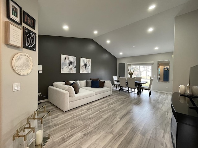 living room featuring vaulted ceiling and light hardwood / wood-style floors