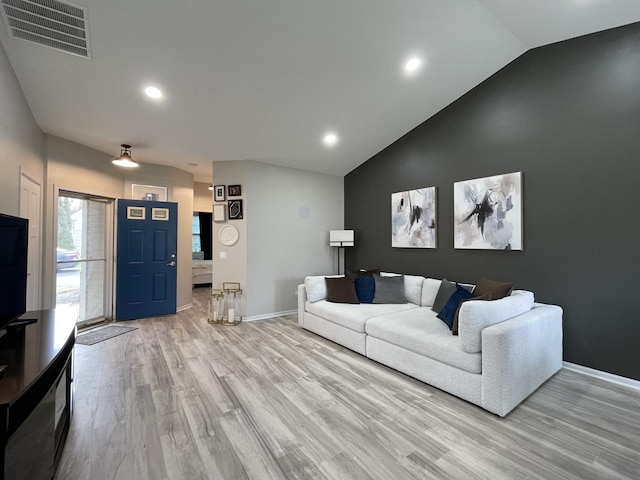 living room with high vaulted ceiling and light hardwood / wood-style floors