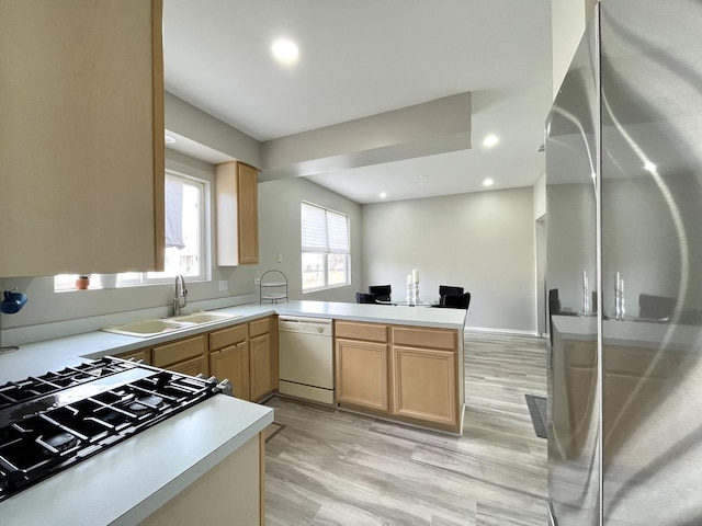 kitchen with dishwasher, light brown cabinets, stainless steel fridge, and kitchen peninsula