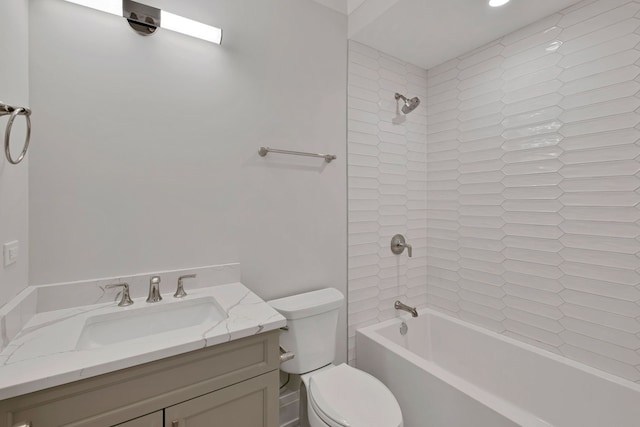 full bathroom with tiled shower / bath, vanity, and toilet