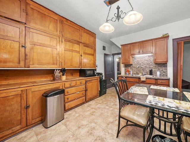 kitchen with hanging light fixtures, tasteful backsplash, and sink