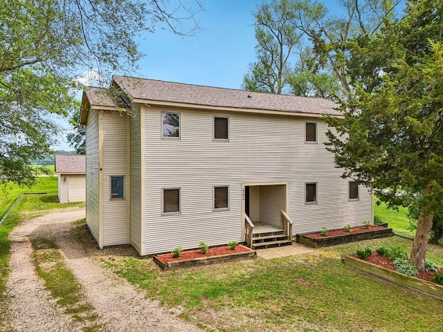 4204 E Dr, Wonder Lake, IL 60097 - rear view of house featuring driveway, a lawn, and a garage