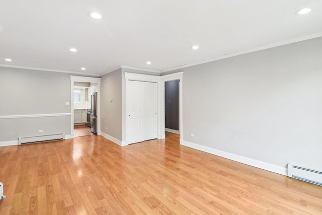 unfurnished room with crown molding, a baseboard radiator, and light hardwood / wood-style floors