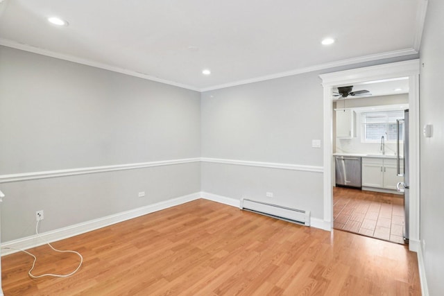 empty room featuring ornamental molding, sink, light hardwood / wood-style flooring, and a baseboard heating unit