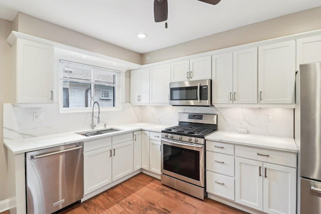 kitchen featuring white cabinetry, appliances with stainless steel finishes, sink, and wood-type flooring