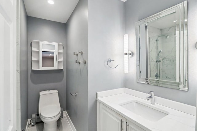 bathroom with vanity, a shower with door, and toilet