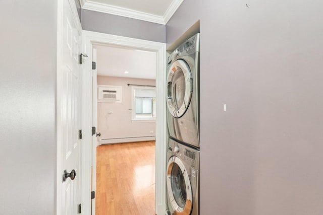 washroom with crown molding, a wall unit AC, stacked washer / drying machine, light hardwood / wood-style floors, and a baseboard radiator