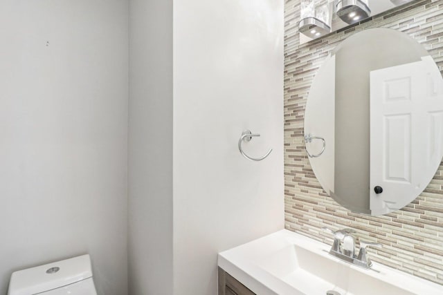 bathroom with tasteful backsplash, vanity, and toilet