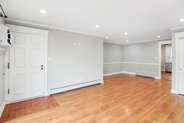 unfurnished room featuring baseboard heating, crown molding, and light wood-type flooring