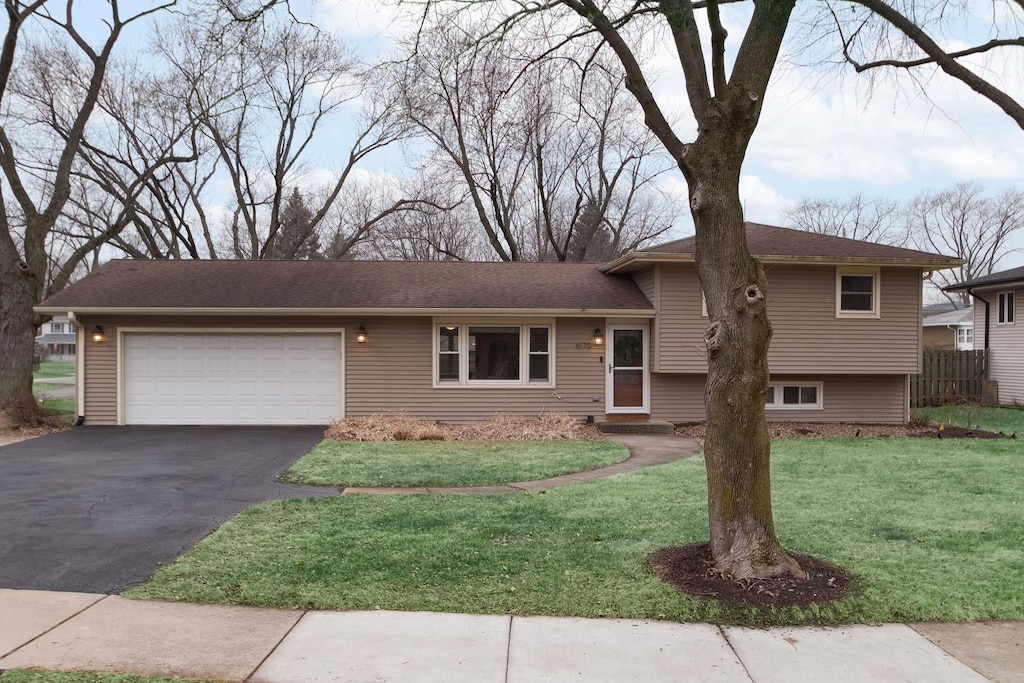 view of front of property with a garage and a front lawn