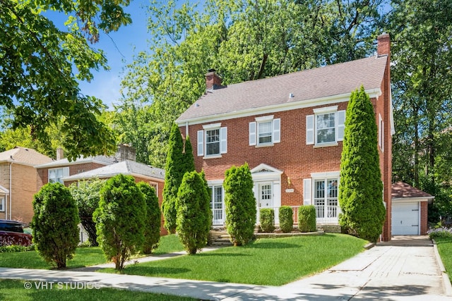 colonial inspired home with a garage and a front lawn