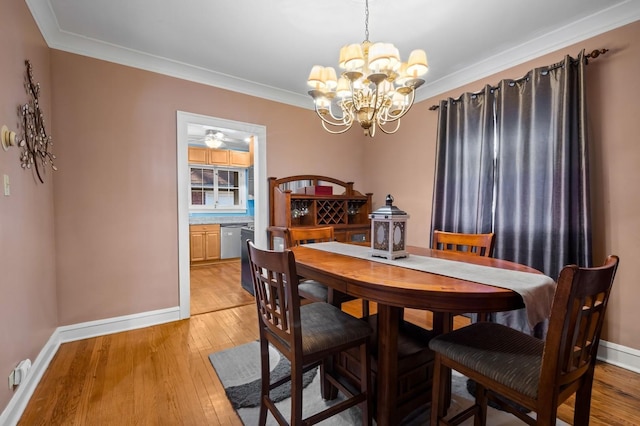 dining space featuring crown molding, a notable chandelier, and light hardwood / wood-style flooring